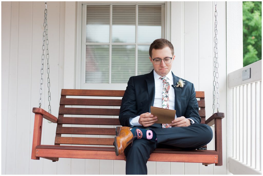 Groom reading letter from bride outside on porch swing