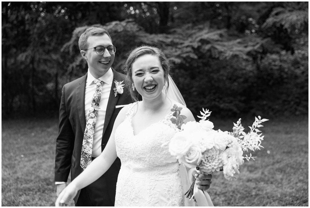 Smiling couple, bride holding floral arrangement made by Essen Events