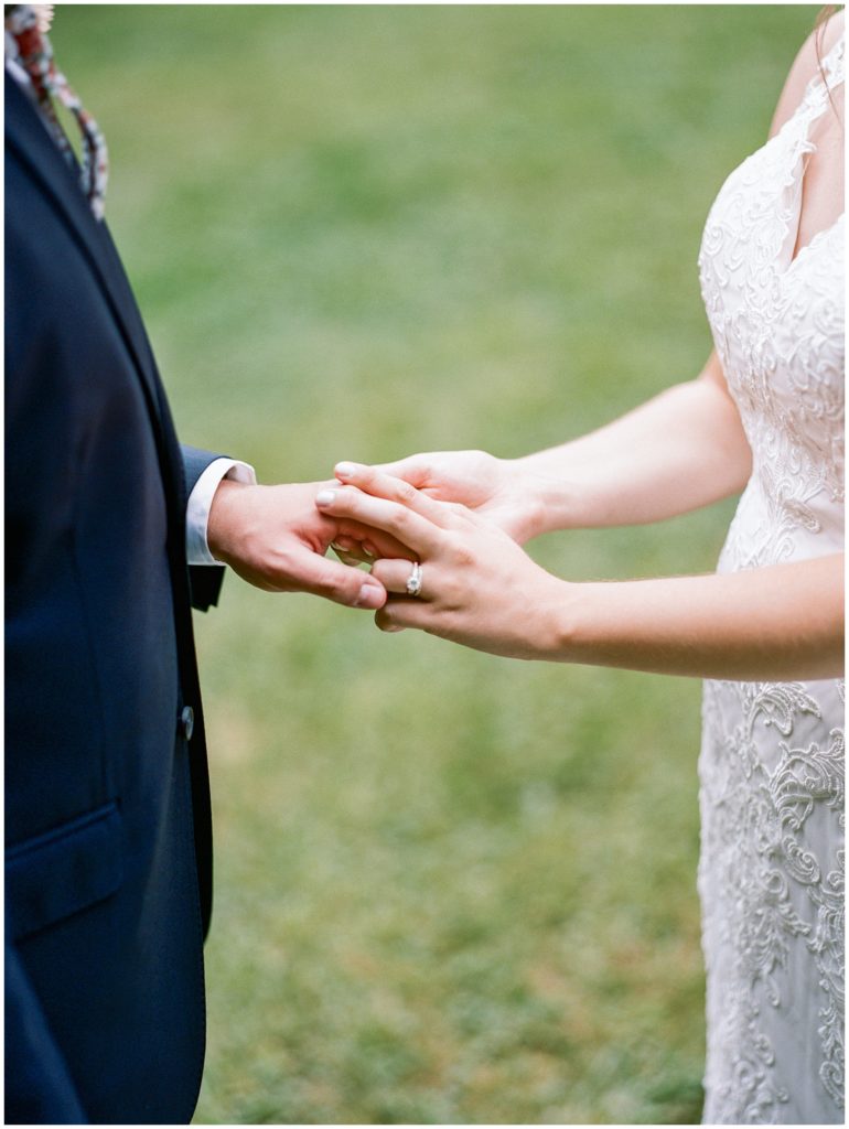 Fine art photography couple holding hands, showing bride's wedding ring