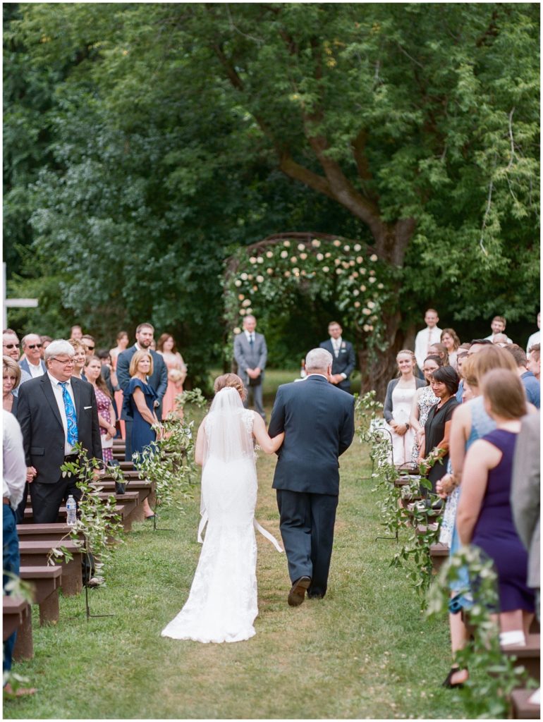 Father and soon-to-be bride walking down outdoor aisle
