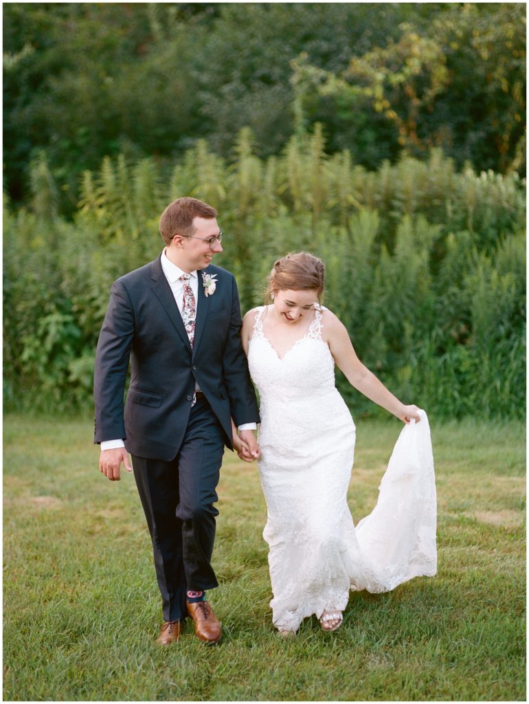Just married couple walking outside surrounded by greenery at Hope Glen Farm in Cottage Grove Minnesota