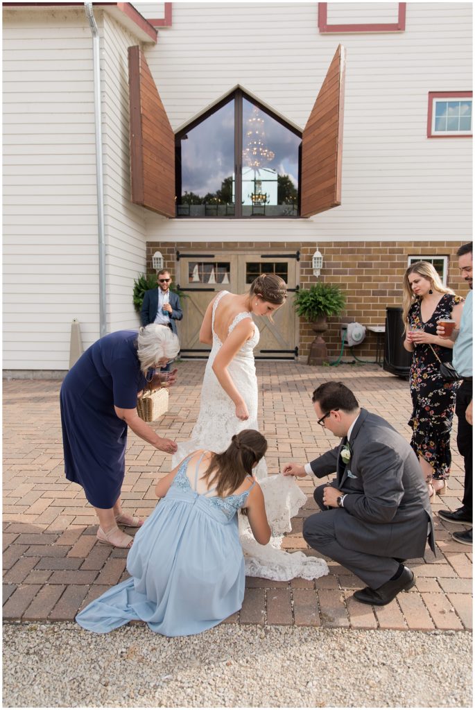 Groom, bridesmaid and guests assisting bride with Effie's Bridal Trunk gown in Eden Prairie, MN.