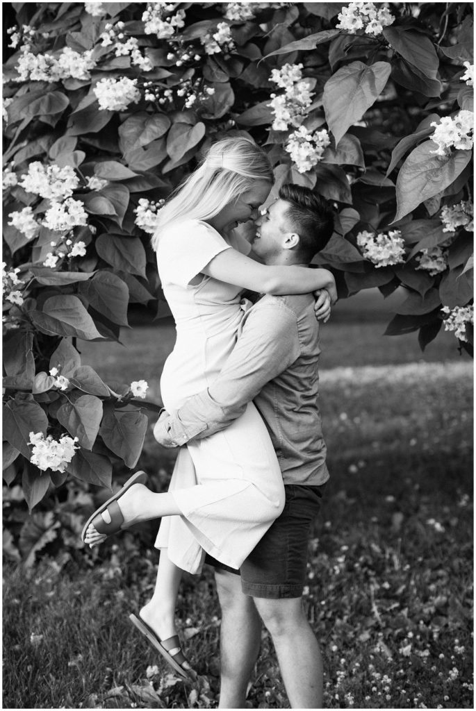 Man lifts woman with a blooming tree surrounding them