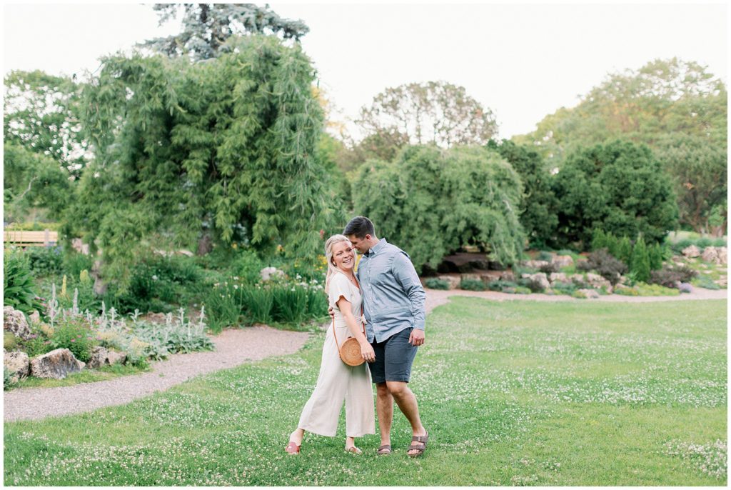 Fine art image of couple laughing and walking in a park in Minneapolis during their lifestyle session