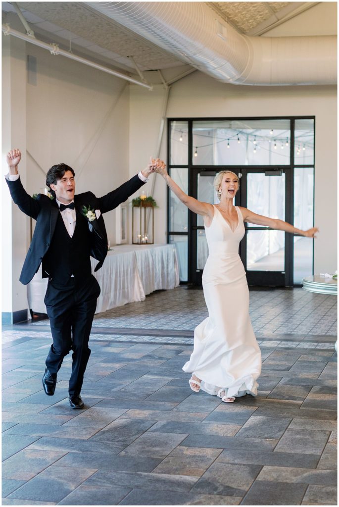 Brie and groom run in during grand march in ballroom wedding Minnesota