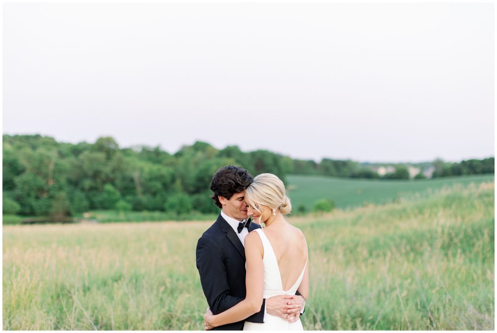 the Byes Photo fine art fun images of a couple hugging in rolling hills at wedding venue in Minnesota