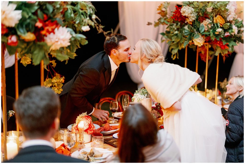 BRie and groom share a kiss at their candlelit tent reception at Minnesota estate