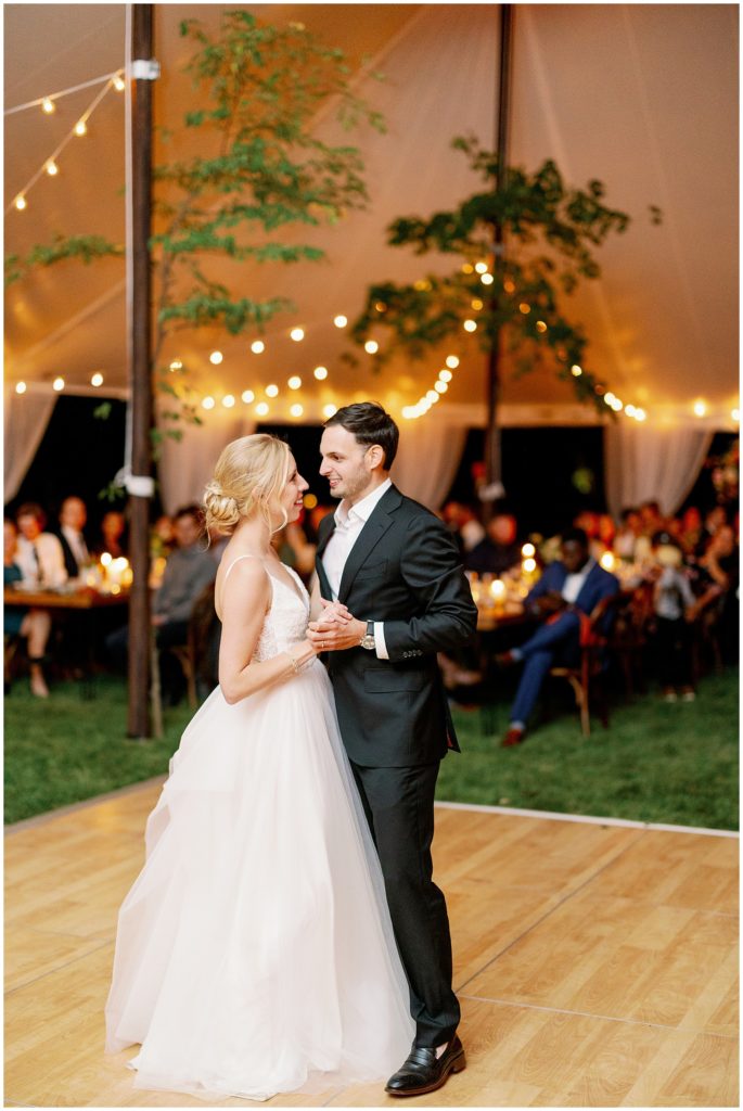 First dance at candlelit tent reception at Minnesota backyard wedding